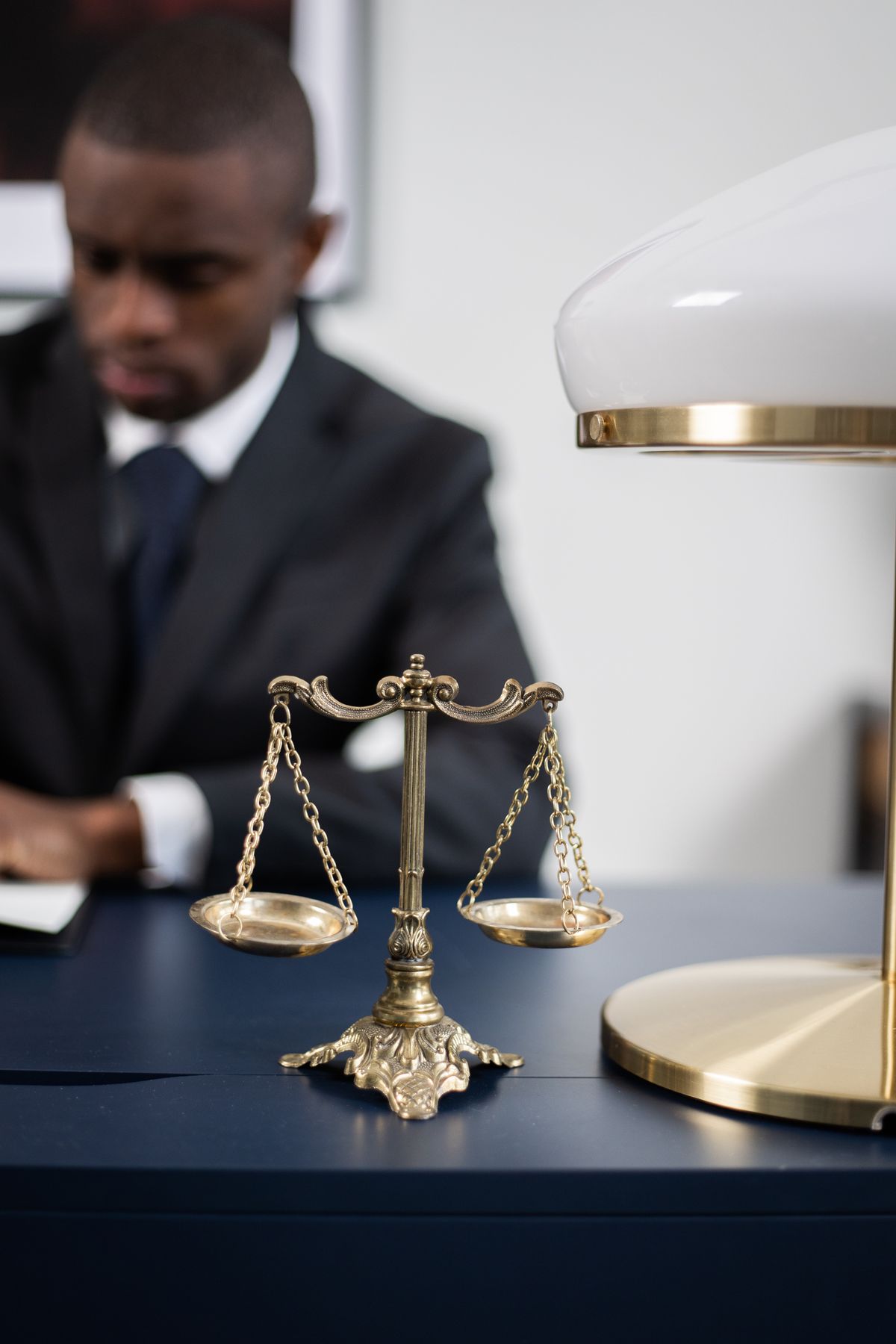 A lawyer at a desk with brass scales of justice